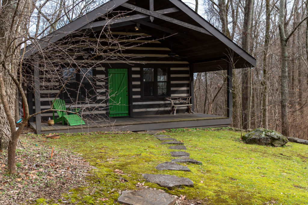J. Paul Moore's log cabin photography studio with moss lawn and stepping stones