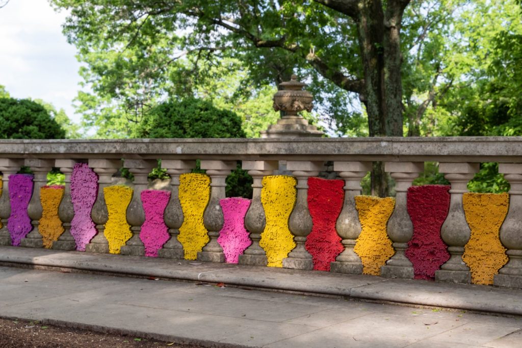 Orange, red, and pink crayons stacked in between the railing columns at Cheekwood mansion